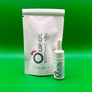Lip oil Soothing Kiss in dropper bottle with packaging on green background