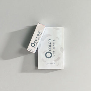Minimalist packaging for O Color Pure White hair or brow dye with sachet and box on gray background