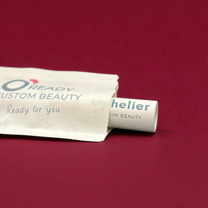 Custom beauty product tube in eco-friendly packaging on burgundy background