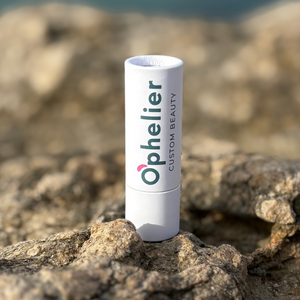 Natural vegan beauty product in white tube packaging on rocky outdoor surface