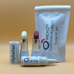 Custom beauty set with two lipsticks, lip oil, and branded pouch on beige background