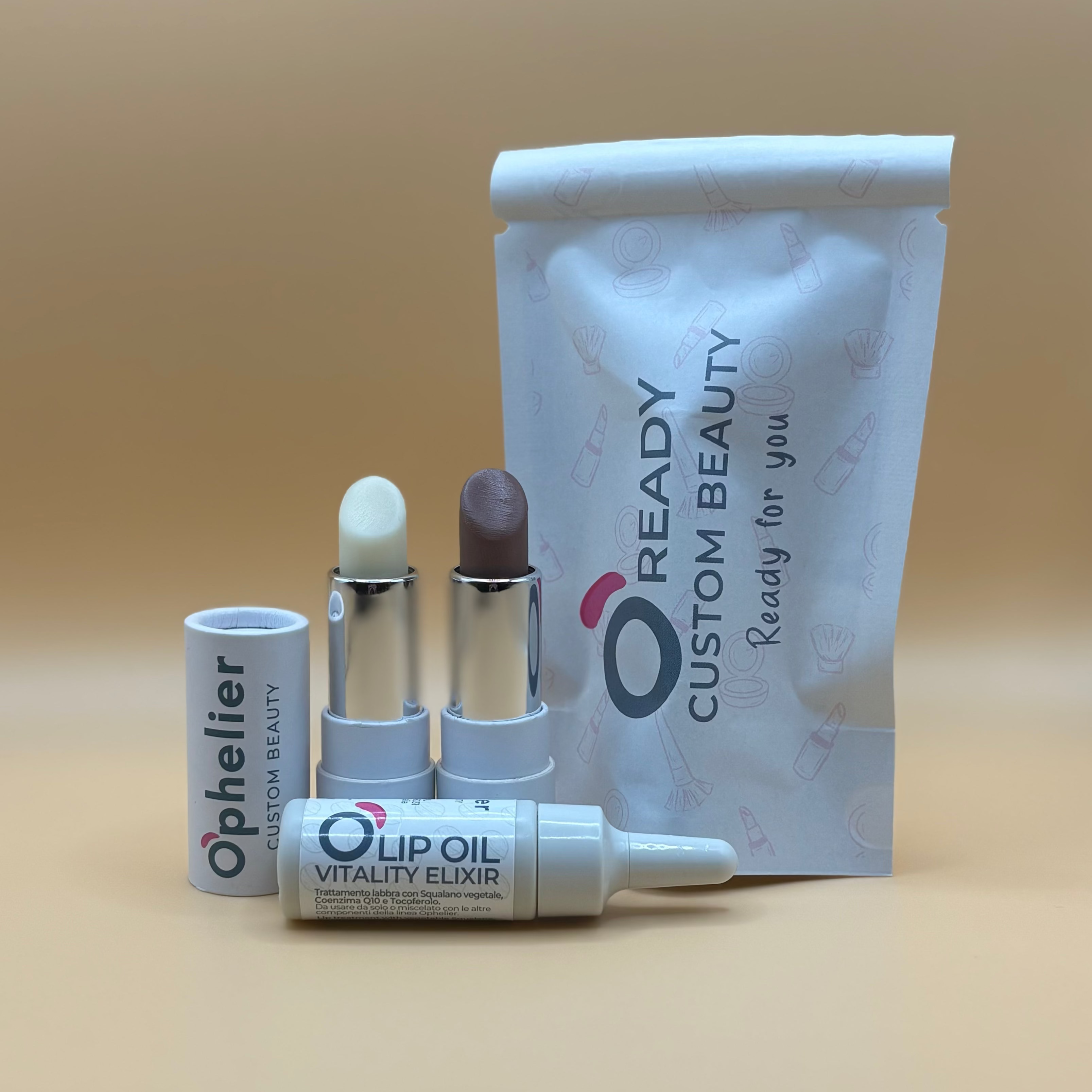 Custom beauty set with two lip balms, lip oil, and branded pouch on beige background