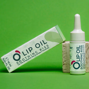 Natural vegan lip oil product with dropper and box on green background