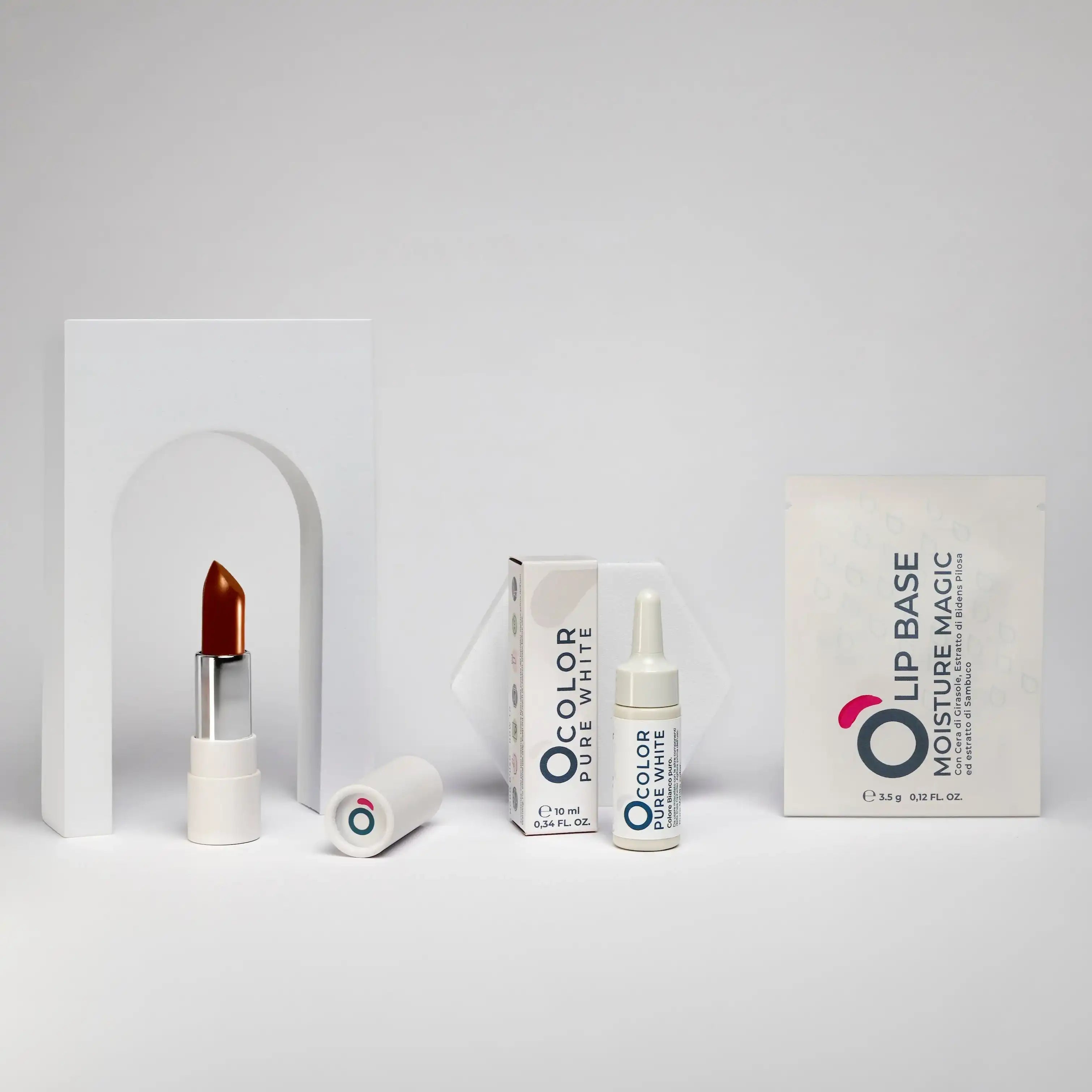 Minimalist display of brown lipstick, lip serum, and lip base makeup products on a white background
