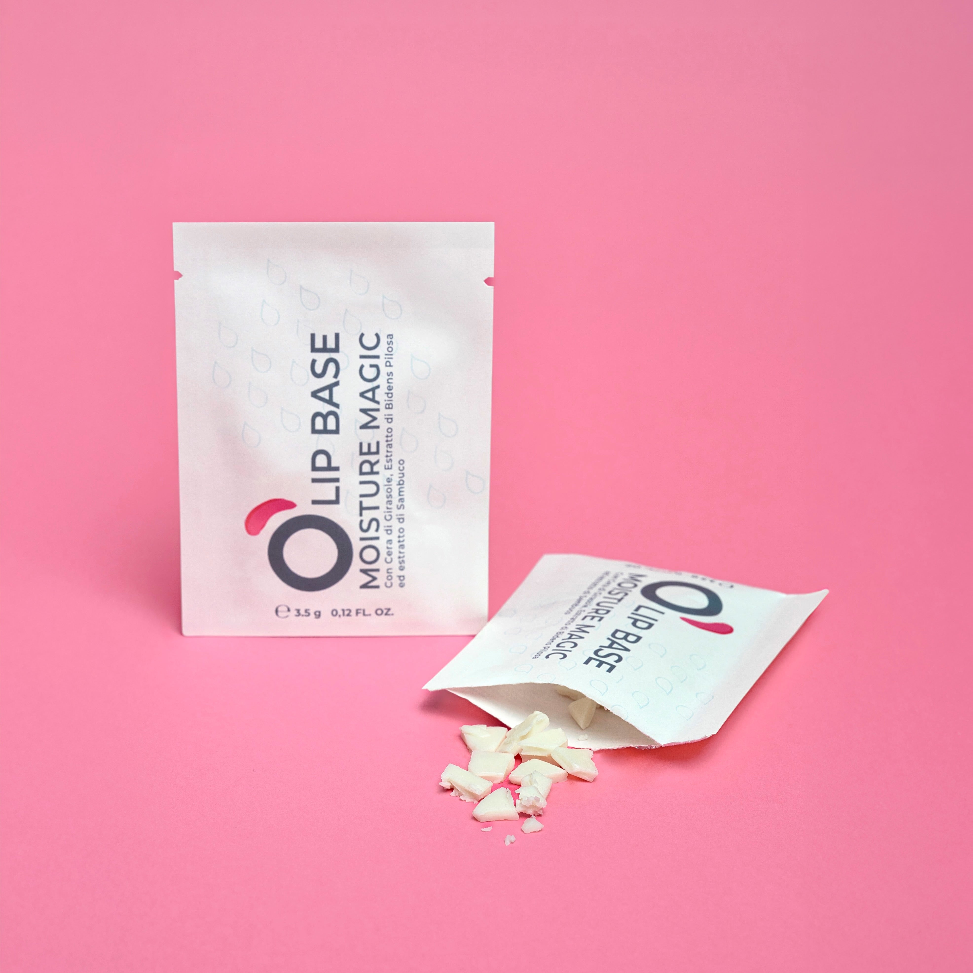 Lip Base Moisture Magic sachets with white cosmetic product on pink background