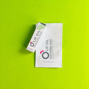 Lip oil Soothing Kiss packaging on bright green background, vegan natural beauty product
