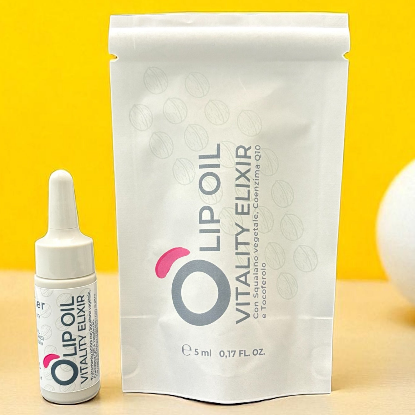 Lip Oil Vitality Elixir vegan natural beauty product in dropper bottle and pouch on yellow background