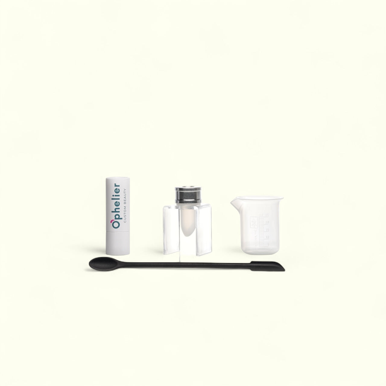 DIY beauty kit with a lipstick tube, mixing container, spatula, and measuring beaker on white background